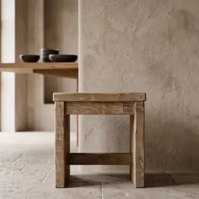 Klassischer niedriger Hocker aus massivem Altholz von BAUHOLZ design in einem modernen Wohnbereich