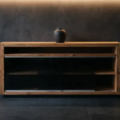 Modernes Lowboard aus massivem Altholz mit dunklen Glasschiebetüren von BAUHOLZ design vor einer dunklen Wand